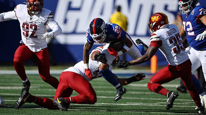 Nov 3, 2024; East Rutherford, New Jersey, USA; New York Giants running back Tyrone Tracy Jr. (29) carries the ball as Washington Commanders linebacker Nick Bellore (57) tackles during the first half at MetLife Stadium. Mandatory Credit: Vincent Carchietta-Imagn Images