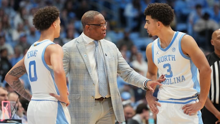 Dec 7, 2025; Chapel Hill, North Carolina, USA; North Carolina Tar Heels head coach Hubert Davis talks with guard Kyan Evans (0) and guard Derek Dixon (3) in the second half at Dean E. Smith Center. Mandatory Credit: Bob Donnan-Imagn Images Dec 7, 2025; Chapel Hill, North Carolina, USA; North Carolina Tar Heels head coach Hubert Davis talks with guard Kyan Evans (0) and guard Derek Dixon (3) in the second half at Dean E. Smith Center. Mandatory Credit: Bob Donnan-Imagn Images