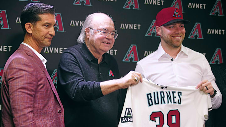 Diamondbacks general manager Mike Hazen (L-R) and managing general partner Ken Kendrick hold a jersey with new starting pitcher Corbin Burnes during an introductory press conference at Chase Field. Diamondbacks general manager Mike Hazen (L-R) and managing general partner Ken Kendrick hold a jersey with new starting pitcher Corbin Burnes during an introductory press conference at Chase Field.