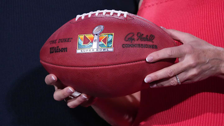 Feb 9, 2026; San Francisco, CA, USA; Los Angeles Sports and Entertainment commission president Kathryn Schloessman  holds a NFL Wilson Duke official football with Super Bowl 61 (LXI) logo at the Super Bowl LX host committee handoff press conference at Moscone Center. Mandatory Credit: Kirby Lee-Imagn Images