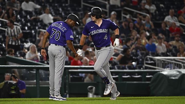 Jun 18, 2025; Washington, District of Columbia, USA; Colorado Rockies first baseman Michael Toglia (4) is congratulated by third base coach Andy González (70) after hitting a solo home run against the Washington Nationals during the sixth inning at Nationals Park. Mandatory Credit: Brad Mills-Imagn Images