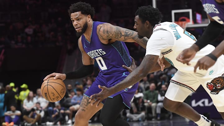 Apr 8, 2025; Charlotte, North Carolina, USA;  Charlotte Hornets forward Miles Bridges (0) drives past Memphis Grizzlies guard forward Vince Williams Jr. (5) during the first half at the Spectrum Center. Mandatory Credit: Sam Sharpe-Imagn Images