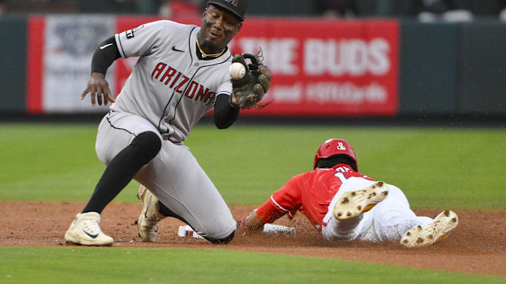 May 23, 2025; St. Louis, Missouri, USA;  Arizona Diamondbacks shortstop Geraldo Perdomo (2) receives the trow as St. Louis Cardinals center fielder Victor Scott II (11) steals second base during the third inning at Busch Stadium. Mandatory Credit: Jeff Curry-Imagn Images