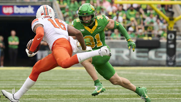 Sep 6, 2025; Eugene, Oregon, USA; Oregon Ducks defensive back Dillon Thieneman (31) runs after Oklahoma State Cowboys wide receiver Christian Fitzpatrick (16) during the first half at Autzen Stadium. Mandatory Credit: Troy Wayrynen-Imagn Images