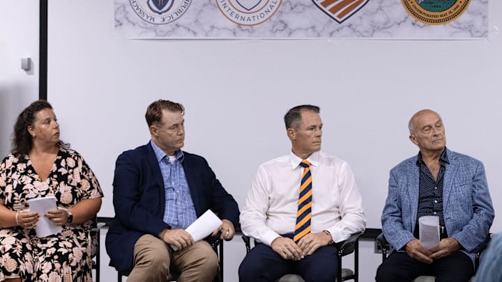 Town administrator Denise Dembowski, Peter Masters, Chris Masters and Richard Odell of Masters Academy International, listen to head of USA Fencing Phil Andrews, during the announcement that Masters Academy International (MAI) will redevelop the former Bose property on Great Road in Stow into a $83 million multi-use sports and education complex, July 31, 2025.