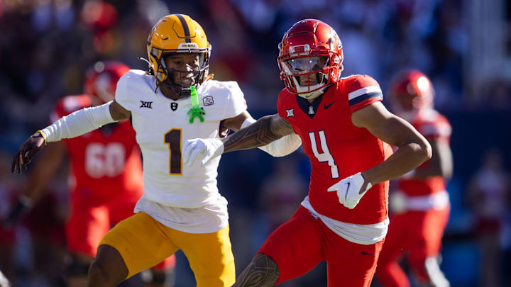 Nov 30, 2024; Tucson, Arizona, USA; Arizona Wildcats wide receiver Tetairoa McMillan (4) against Arizona State Sun Devils defensive back Keith Abney II (1) during the Territorial Cup at Arizona Stadium. Mandatory Credit: Mark J. Rebilas-Imagn Images