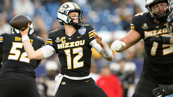 Dec 30, 2024; Nashville, TN, USA;  Missouri Tigers quarterback Brady Cook (12) throws a pass against the Iowa Hawkeyes during the second half at Nissan Stadium. Mandatory Credit: Steve Roberts-Imagn Images