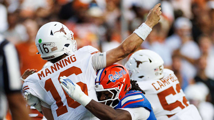 Texas Longhorns quarterback Arch Manning throws under pressure from Florida Gators linebacker Myles Graham 
