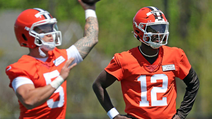 Cleveland Browns quarterback Shedeur Sanders (12) watches as quarterback Dillon Gabriel (5) throws during NFL rookie minicamp at the Cleveland Browns training facility on Friday, May 9, 2025, in Berea, Ohio.