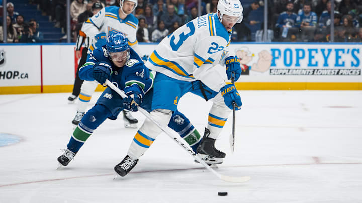 Oct 13, 2025; Vancouver, British Columbia, CAN; Vancouver Canucks forward Aatu Raty (54) stick checks St. Louis Blues defenseman Logan Mailloux (23) in the second period at Rogers Arena. Mandatory Credit: Bob Frid-Imagn Images