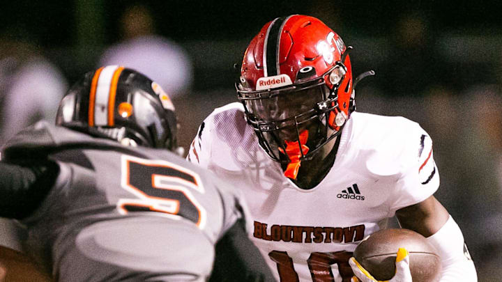 Blountstown Tigers Jordan Pride (10) drives upfield while meeting Hawthorne Hornets Jordin Fluellen