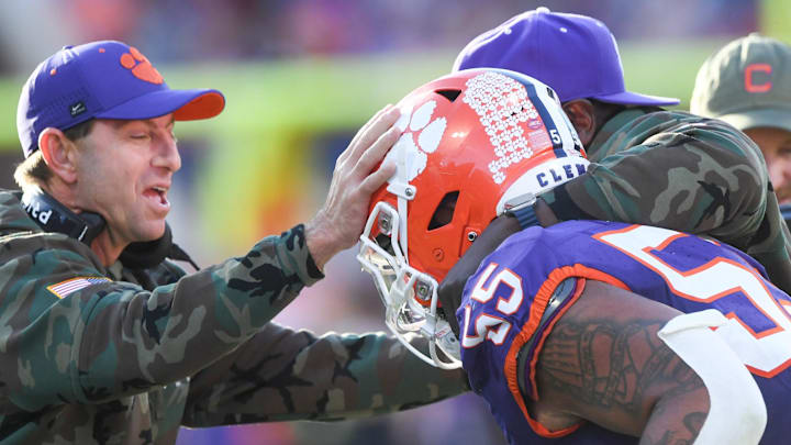 Nov 23, 2024; Clemson, South Carolina, USA; Clemson Tigers head coach Dabo Swinney and defensive tackles coordinator Nick Eason hug defensive tackle Payton Page (55) after Page returned an interception for a touchdown during the first quarter against The Citadel Bulldogs at Memorial Stadium. Nov 23, 2024; Clemson, South Carolina, USA; Clemson Tigers head coach Dabo Swinney and defensive tackles coordinator Nick Eason hug defensive tackle Payton Page (55) after Page returned an interception for a touchdown during the first quarter against The Citadel Bulldogs at Memorial Stadium.