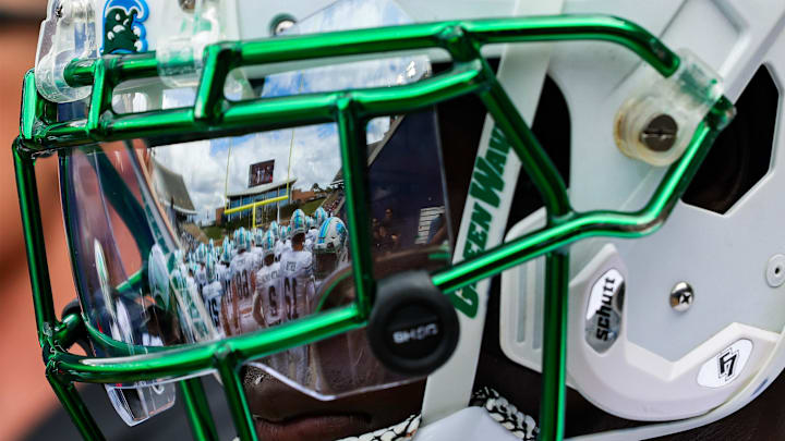 Oct 28, 2023; Houston, Texas, USA; The facemark of Tulane Green Wave defensive back Rayshawn Pleasant (25) reflects his teammates as he warms up before a game against the Rice Owls. Oct 28, 2023; Houston, Texas, USA; The facemark of Tulane Green Wave defensive back Rayshawn Pleasant (25) reflects his teammates as he warms up before a game against the Rice Owls.