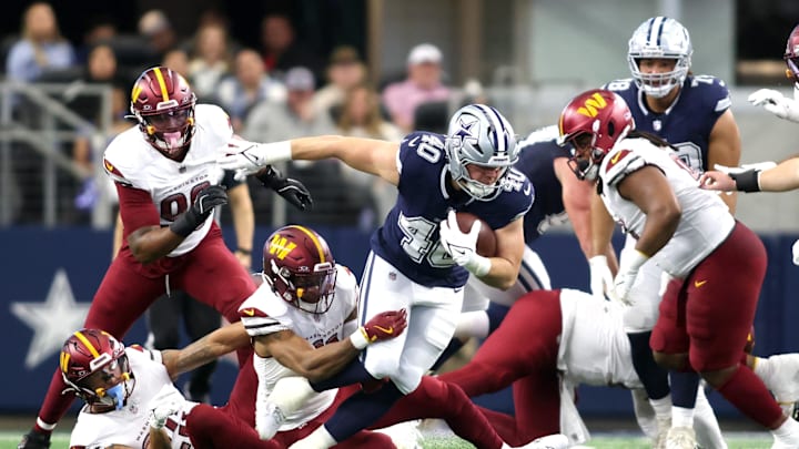 Dallas Cowboys running back Hunter Luepke is tackled by Washington Commanders safety Jeremy Chinn during the first half at AT&T Stadium. 