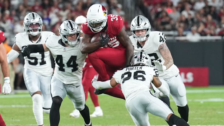 Aug 23, 2025; Glendale, Arizona, USA; Arizona Cardinals running back Bam Knight (35) hurdles Las Vegas Raiders defenders during the first half at State Farm Stadium. Mandatory Credit: Joe Camporeale-Imagn Images