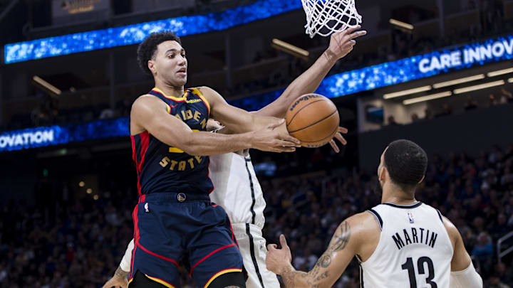 Nov 25, 2024; San Francisco, California, USA; Golden State Warriors forward Trayce Jackson-Davis (32) gets a rebound in front of Brooklyn Nets guard Tyrese Martin (13) during the second half at Chase Center. Mandatory Credit: John Hefti-Imagn Images