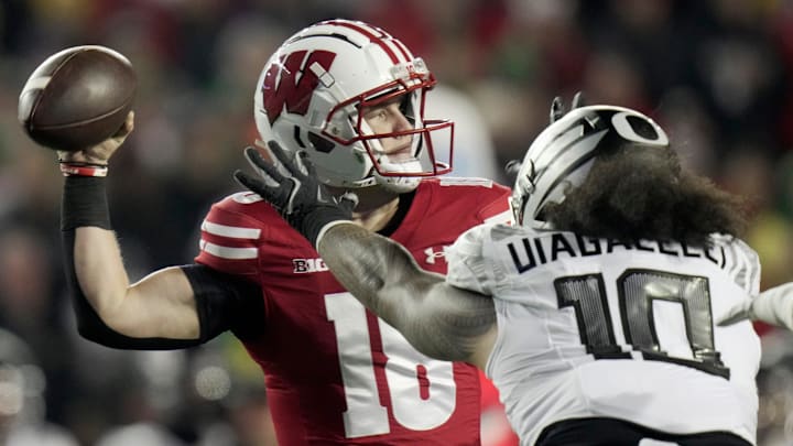 Wisconsin quarterback Braedyn Locke (18) is pressured by Oregon defensive end Matayo Uiagalelei (10) during the first quarter of their game Saturday, November 16, 2024 at Camp Randall Stadium in Madison, Wisconsin.