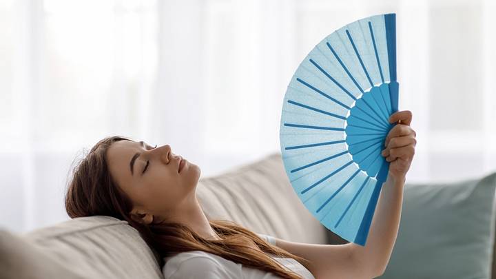 Woman fanning face Woman fanning face