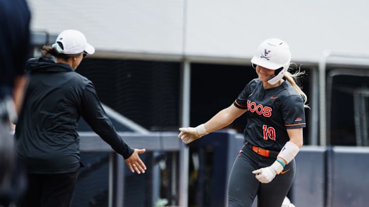 Virginia softball's Jade Hylton high-fives head coach Joanna Hardin as she rounds third after hitting a home run.