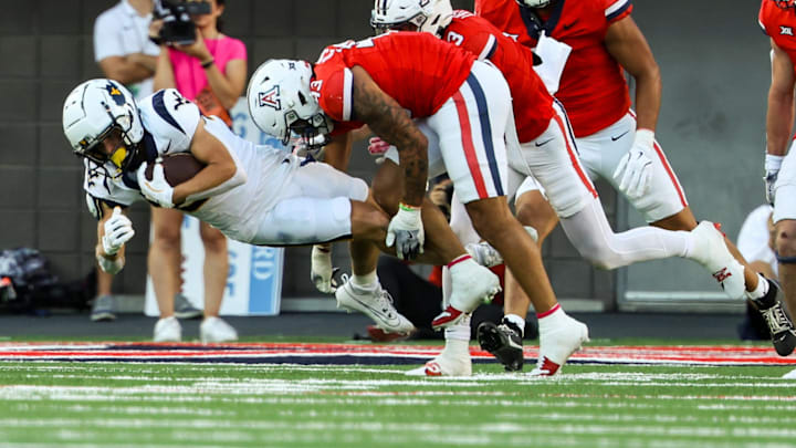 Oct 26, 2024; Tucson, Arizona, USA; Arizona Wildcats defensive back Dalton Johnson (43) tackles West Virginia Mountaineers during the second quarter at Arizona Stadium. Mandatory Credit: Aryanna Frank-Imagn Images Oct 26, 2024; Tucson, Arizona, USA; Arizona Wildcats defensive back Dalton Johnson (43) tackles West Virginia Mountaineers during the second quarter at Arizona Stadium. Mandatory Credit: Aryanna Frank-Imagn Images