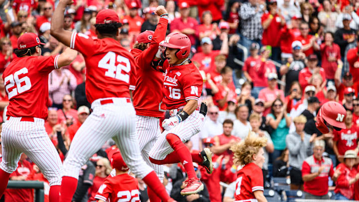 Devin Nunez (16) celebrates his home run with the Husker dugout. 