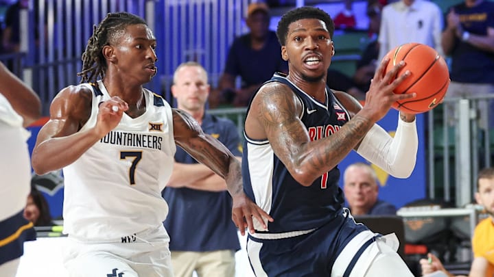 Nov 29, 2024; Paradise Island, Bahamas, BHS;  Arizona Wildcats guard Caleb Love (1) drives to the basket as West Virginia Mountaineers guard Javon Small (7) defends during the first half at Imperial Arena at the Atlantis resort. 