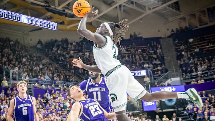 Michigan State's Kur Teng bowls over the UW's JJ Mandaquit on his way to the basket. 