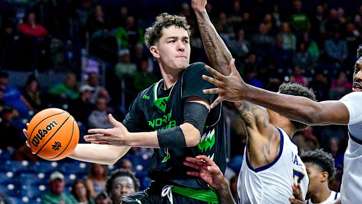 Nov 19, 2024; South Bend, Indiana, USA; North Dakota Fighting Hawks guard Treysen Eaglestaff (52) passes the ball as Notre Dame Fighting Irish forward Tae Davis (7) and forward Kebba Njie (14) defend in the second half at the Purcell Pavilion. Nov 19, 2024; South Bend, Indiana, USA; North Dakota Fighting Hawks guard Treysen Eaglestaff (52) passes the ball as Notre Dame Fighting Irish forward Tae Davis (7) and forward Kebba Njie (14) defend in the second half at the Purcell Pavilion.