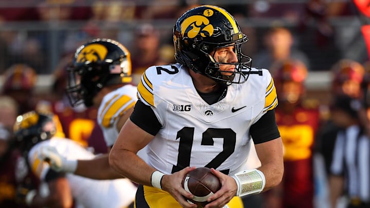 Sep 21, 2024; Minneapolis, Minnesota, USA; Iowa Hawkeyes quarterback Cade McNamara (12) takes a snap against the Minnesota Golden Gophers during the first half at Huntington Bank Stadium. Mandatory Credit: Matt Krohn-Imagn Images