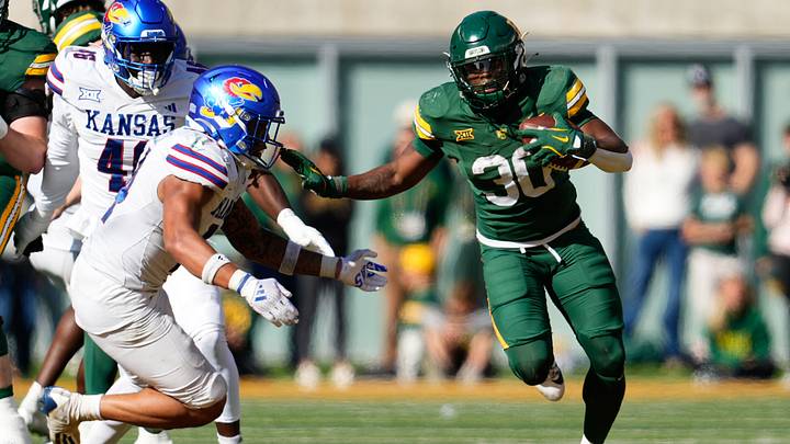 Nov 30, 2024; Waco, Texas, USA; Baylor Bears running back Bryson Washington (30) runs the ball as Kansas Jayhawks safety Jalen Dye (14) defends during the second half at McLane Stadium. Mandatory Credit: Chris Jones-Imagn Images Nov 30, 2024; Waco, Texas, USA; Baylor Bears running back Bryson Washington (30) runs the ball as Kansas Jayhawks safety Jalen Dye (14) defends during the second half at McLane Stadium. Mandatory Credit: Chris Jones-Imagn Images