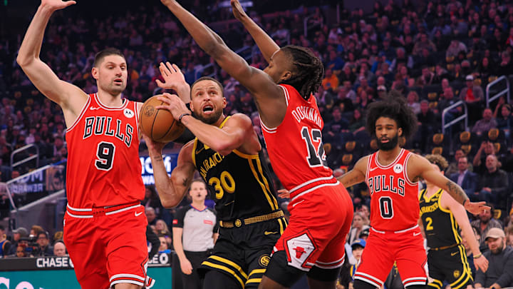Mar 7, 2024; San Francisco, California, USA; Golden State Warriors guard Stephen Curry (30) drives between Chicago Bulls center Nikola Vucevic (9) and guard Ayo Dosunmu (12) during the first quarter at Chase Center. Mandatory Credit: Kelley L Cox-Imagn Images