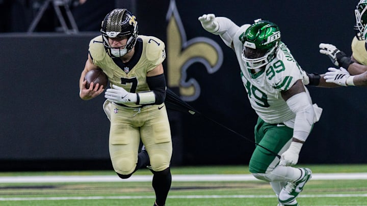 Dec 21, 2025; New Orleans, Louisiana, USA;  New York Jets defensive tackle Khalen Saunders (99) attempts to tackle New Orleans Saints tight end Taysom Hill (7) during the second half  at Caesars Superdome. Mandatory Credit: Stephen Lew-Imagn Images