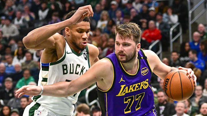 Mar 13, 2025; Milwaukee, Wisconsin, USA;  Los Angeles Lakers guard Luka Doncic (77) drives to the basket against Milwaukee Bucks forward Giannis Antetokounmpo (34) in the third quarter at Fiserv Forum. Mandatory Credit: Benny Sieu-Imagn Images