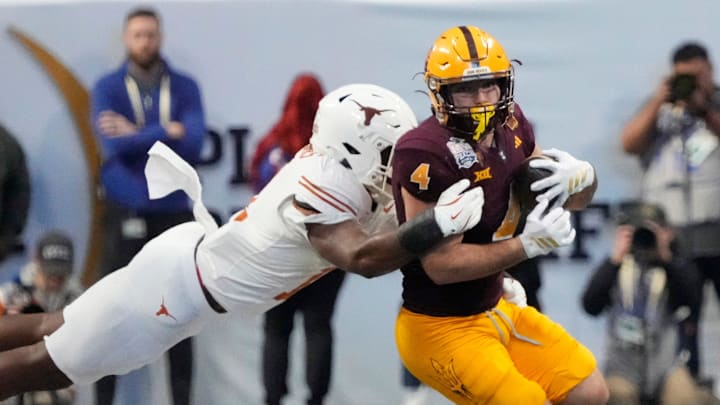 Arizona State running back Cam Skattebo (4) is tackled by Texas linebacker Colin Simmons (11) during the fourth quarter in the Chick-fil-A Peach Bowl in Atlanta on Wednesday, Jan. 1, 2025. Arizona State running back Cam Skattebo (4) is tackled by Texas linebacker Colin Simmons (11) during the fourth quarter in the Chick-fil-A Peach Bowl in Atlanta on Wednesday, Jan. 1, 2025.