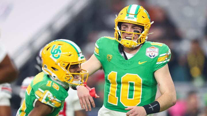 Jan 1, 2024; Glendale, AZ, USA; Oregon Ducks quarterback Bo Nix (10) celebrates a touchdown with  wide receiver Tez Johnson (15) during the second half against the Liberty Flames in the 2024 Fiesta Bowl at State Farm Stadium. Mandatory Credit: Mark J. Rebilas-Imagn Images