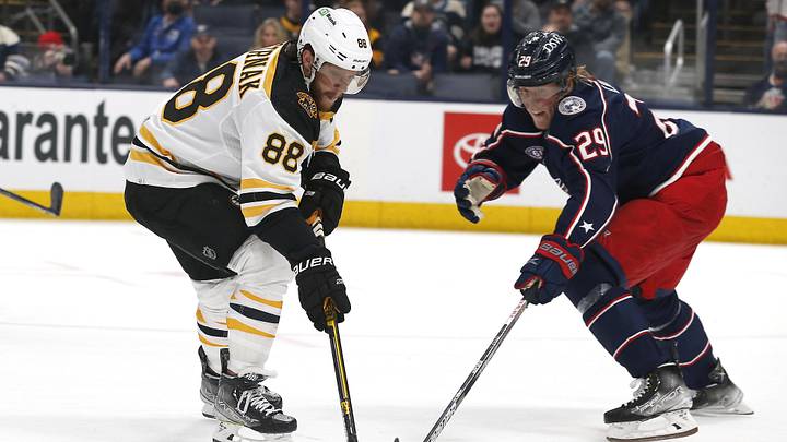 Mar 5, 2022; Columbus, Ohio, USA; Boston Bruins right wing David Pastrnak (88) pushes the puck past the stick of Columbus Blue Jackets right wing Patrik Laine (29) during overtime at Nationwide Arena. Mandatory Credit: Russell LaBounty-Imagn Images