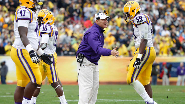 Jan 1, 2014; Tampa, Fl, USA; LSU Tigers head coach Les Miles congratulates defensive end Jermauria Rasco (59) and teammates during the second half against the Iowa Hawkeyes at Raymond James Stadium. LSU Tigers defeated the Iowa Hawkeyes 21-14. Mandatory Credit: Kim Klement-Imagn Images