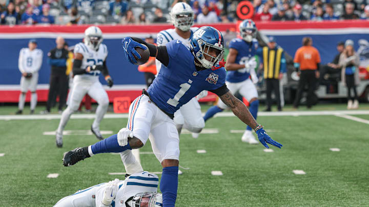  New York Giants wide receiver Malik Nabers (1) breaks a tackle by Indianapolis Colts safety Julian Blackmon (32) during a touchdown reception during the first half at MetLife Stadium.  