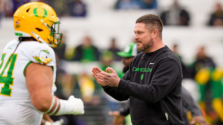 Oregon head coach Dan Lanning, right, walks the field during warmups as the Oregon Ducks take on the Washington Huskies on Nov. 29, 2025, at Husky Stadium in Seattle, Washington.