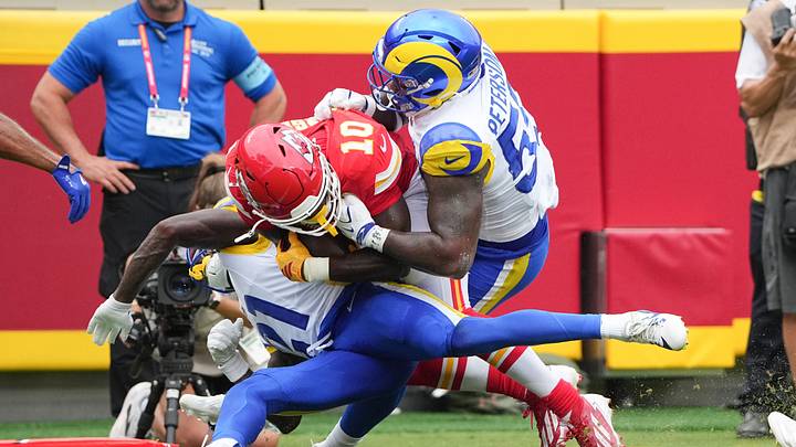 Aug 15, 2026; Kansas City, Missouri, USA; Kansas City Chiefs running back Emmett Johnson (10) runs the ball as Los Angeles Rams linebacker Darryl Peterson III (59) makes the tackle during the first half of the pre season at Arrowhead Stadium. Mandatory Credit: Denny Medley-Imagn Images