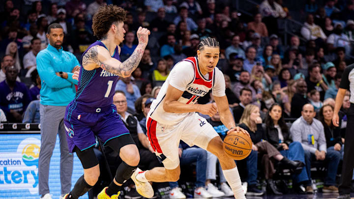 Mar 1, 2025; Charlotte, North Carolina, USA; Washington Wizards forward Kyshawn George (18) drives on Charlotte Hornets guard LaMelo Ball (1) during the fourth quarter at Spectrum Center. Mandatory Credit: Scott Kinser-Imagn Images