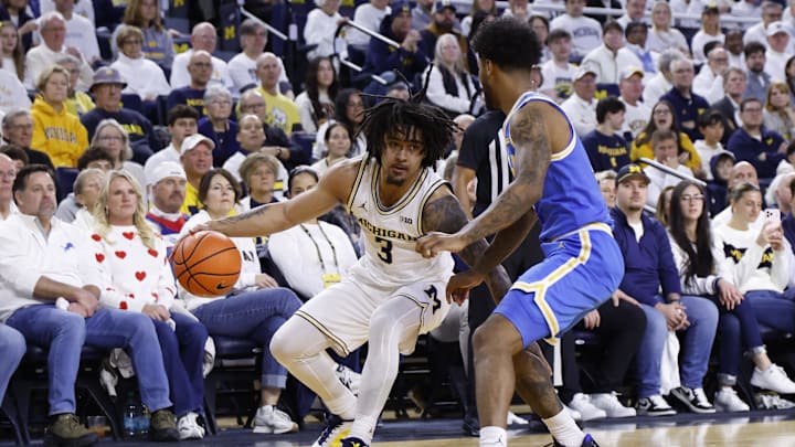 Feb 14, 2026; Ann Arbor, Michigan, USA; Michigan Wolverines guard Elliot Cadeau (3) dribbles defended by UCLA Bruins guard Donovan Dent (2) in the first half at Crisler Center. 