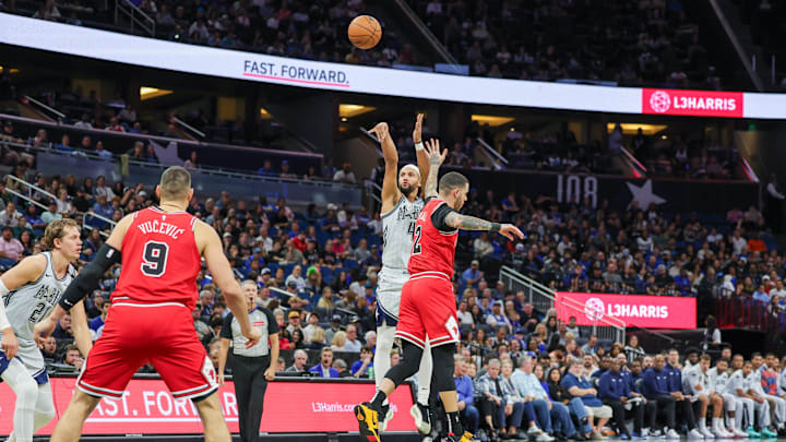 Orlando Magic guard Jalen Suggs (4) shoots a three-point basket against Chicago Bulls guard Lonzo Ball (2) during the second quarter at Kia Center.