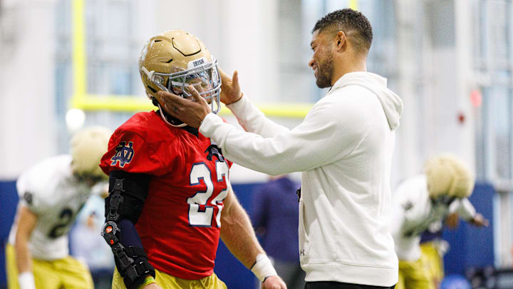Head coach Marcus Freeman, right, taps running back Aneyas Williams on the helmet during a Notre Dame football practice at Irish Athletic Center on Friday, March 20, 2026, in South Bend.