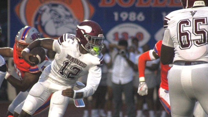 Raines quarterback T.J. Cole (12) scrambles away from pressure as guard Solomon Thomas (65) blocks against Bolles during a high school football game on August 23, 2024. [Clayton Freeman/Florida Times-Union]