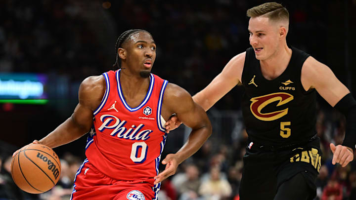 Dec 21, 2024; Cleveland, Ohio, USA; Philadelphia 76ers guard Tyrese Maxey (0) drives to the basket against Cleveland Cavaliers guard Sam Merrill (5) during the first half at Rocket Mortgage FieldHouse. Mandatory Credit: Ken Blaze-Imagn Images