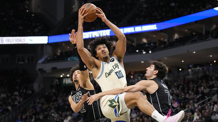 Apr 10, 2026; Milwaukee, Wisconsin, USA;  Milwaukee Bucks center Jericho Sims (00) grabs a rebound between Brooklyn Nets forward Jalen Wilson (22) and guard Ben Saraf (77) during the second quarter at Fiserv Forum. Mandatory Credit: Jeff Hanisch-Imagn Images