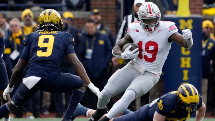 Ohio State Buckeyes running back Chip Trayanum dodges Michigan Wolverines defensive back Rod Moore