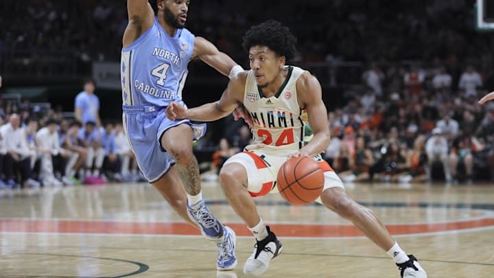 Feb 10, 2024; Coral Gables, Florida, USA; Miami Hurricanes guard Nijel Pack (24) drives to the basket past North Carolina Tar Heels guard RJ Davis (4) during the second half at Watsco Center. Mandatory Credit: Sam Navarro-Imagn Images