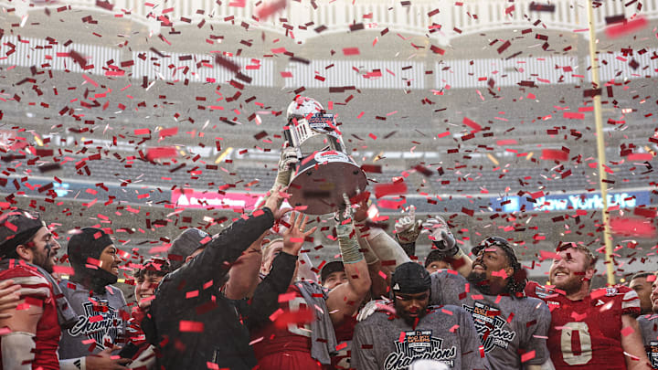Dec 28, 2024; Bronx, NY, USA; Nebraska Cornhuskers head coach Matt Rhule holds the championship trophy as Cornhuskers players celebrate after the game against the Boston College Eagles at Yankee Stadium. 